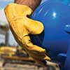 Construction worker standing in front of a backhoe holding a hard hat